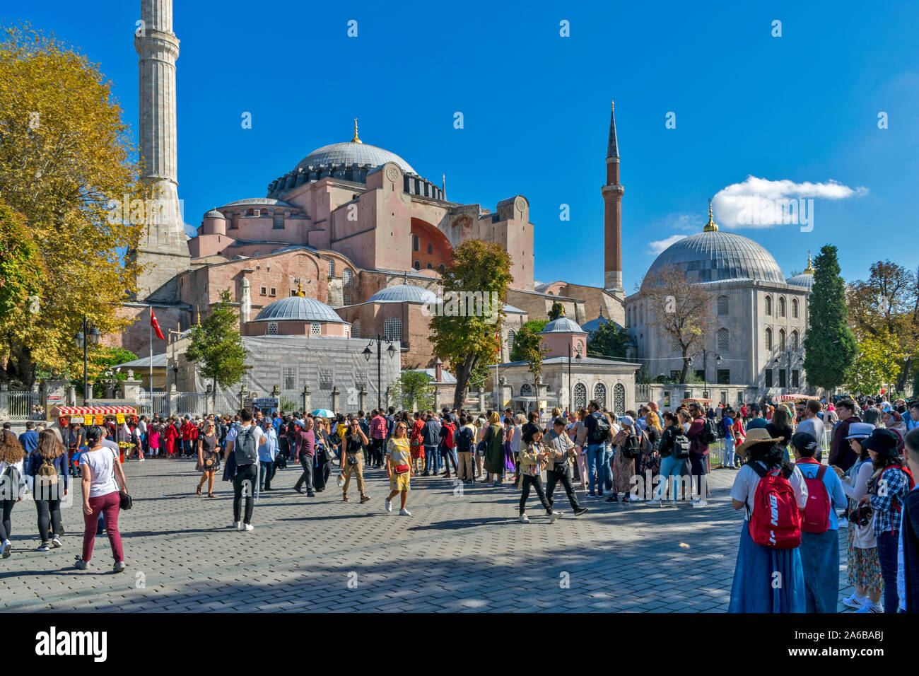 ISTANBUL TURKEY HAGIA SOPHIA WITH AUTUMNAL TREES AND LEAVES AND TOURISTS QUEUING TO ENTER THE BUILDING Stock Photo