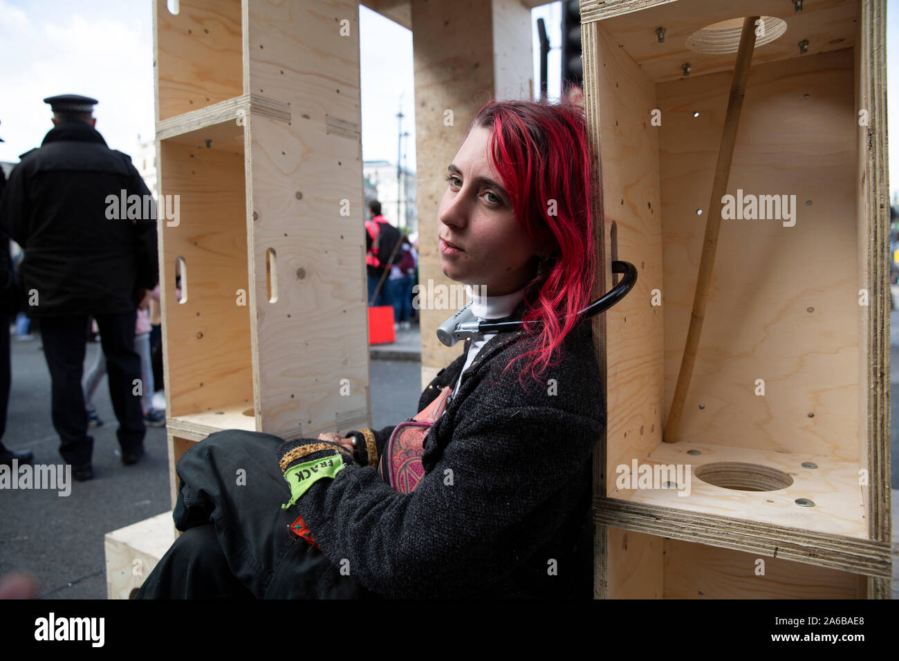 London, 10th October 2019, Extinction Rebellion demonstrator has locked herself to a timber structure occupying part of the road beside Trafalgar Square, awaiting arrest. Stock Photo