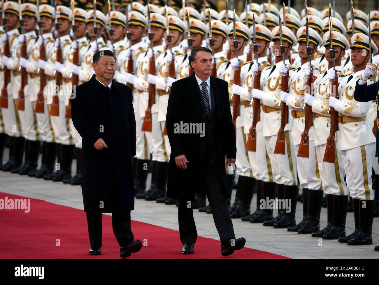 Beijing, China. 25th Oct, 2019. Brazilian President Jair Bolsonaro (R) is escorted by Chinese President Xi Jinping during a welcoming ceremony at the Great Hall of the People in Beijing on Friday, October 25, 2019. Bolsonaro told a forum that China and Brazil 'were born to walk together' and the two governments are 'completely aligned in a way that reaches beyond our commercial and business relationship.' Photo by Stephen Shaver/UPI Credit: UPI/Alamy Live News Stock Photo