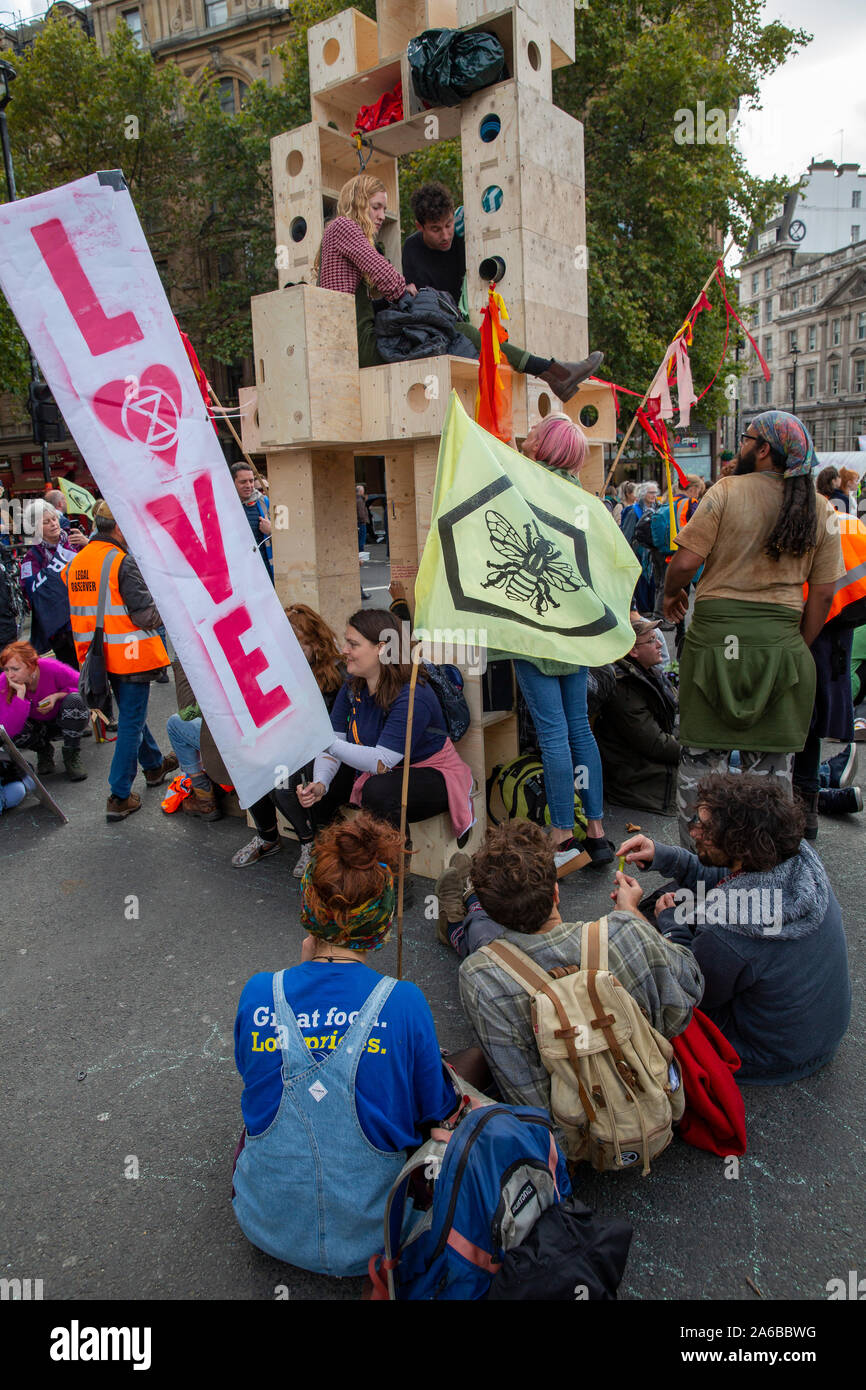 London, 10th October 2019, Extinction Rebellion demonstrator has locked himself to a timber structure occupying part of the road beside Trafalgar Square, awaiting arrest. Stock Photo