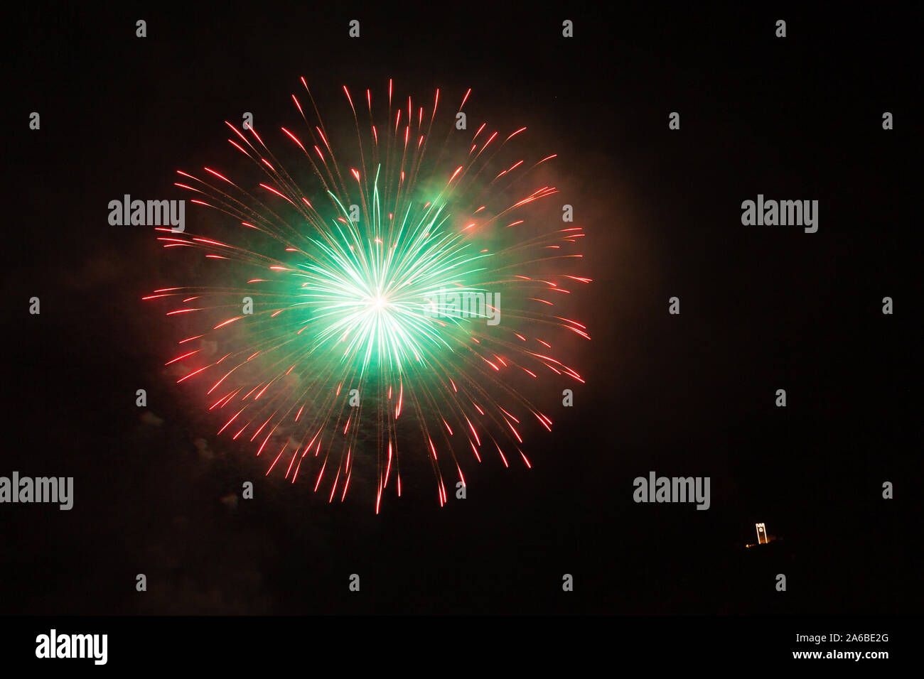 Awesome red, white and green fireworks above a illuminated church Stock Photo