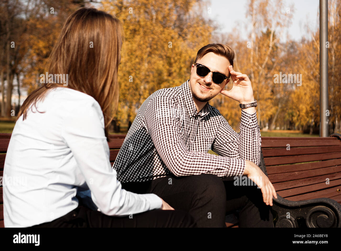 Happy smiling couple on park bench in fall sunny day Stock Photo - Alamy