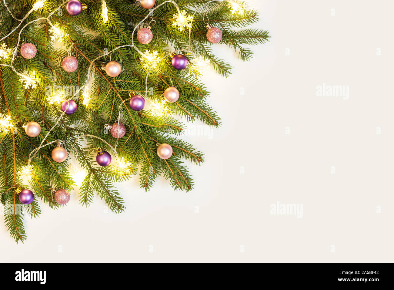 Christmas Composition Of Fresh Spruce Branches Decorated With Pink And Purple Christmas Baubles And Snowflakes Lights On A White Background Stock Photo Alamy