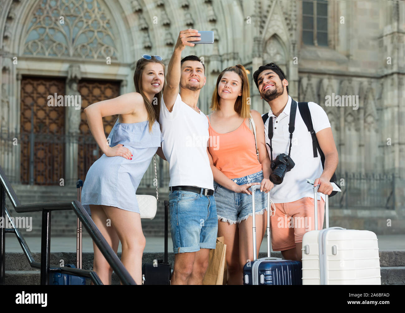 cheerful group of friends doing selfies on a phone on the street Stock Photo
