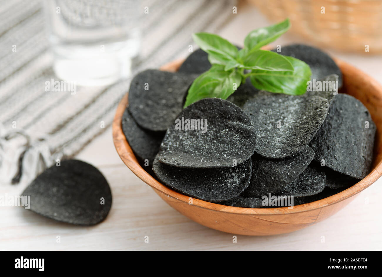 Black spicy potato chips in wooden  bowl Stock Photo