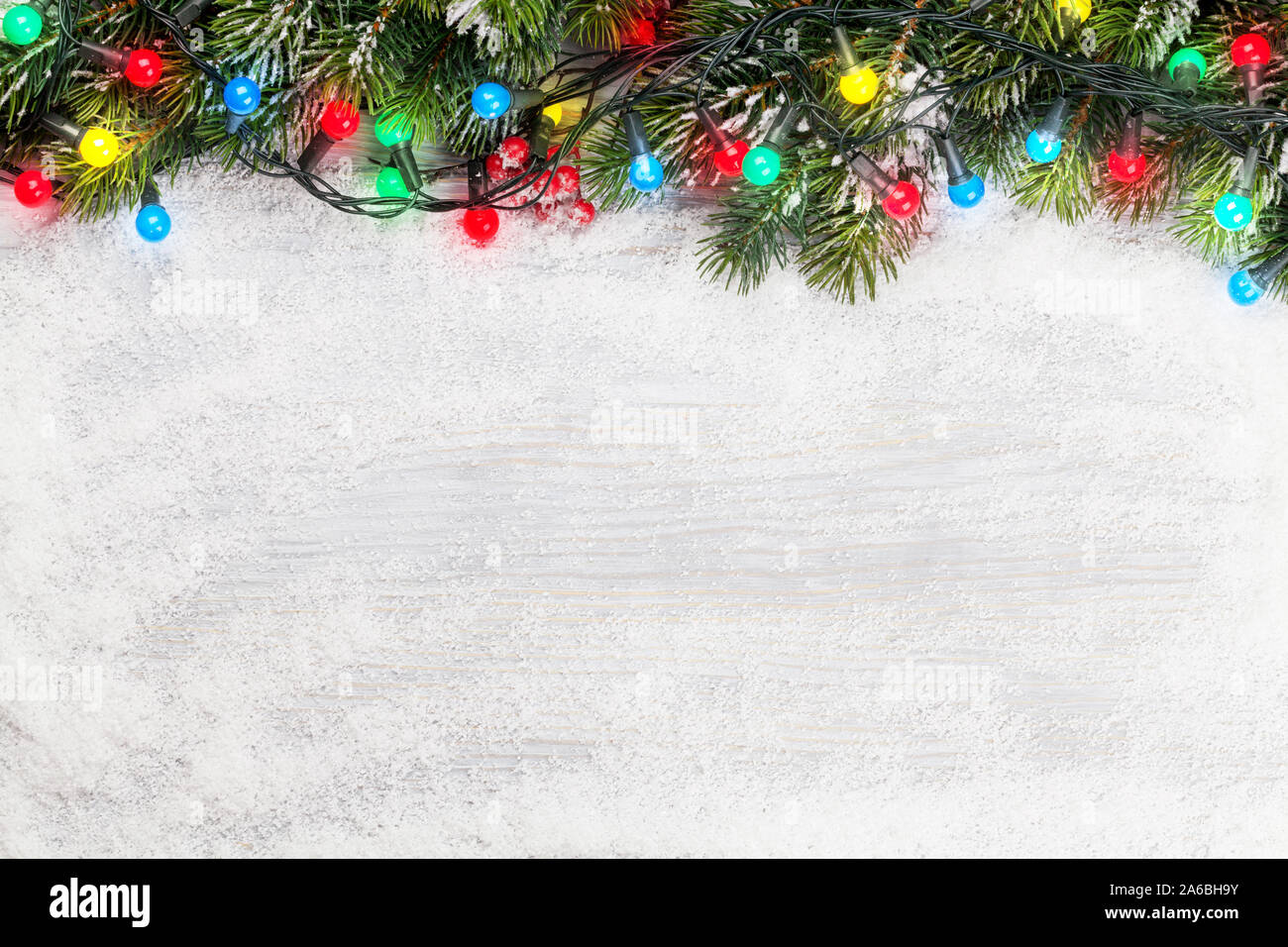 Christmas greeting card with fir tree and colorful lights over snow ...