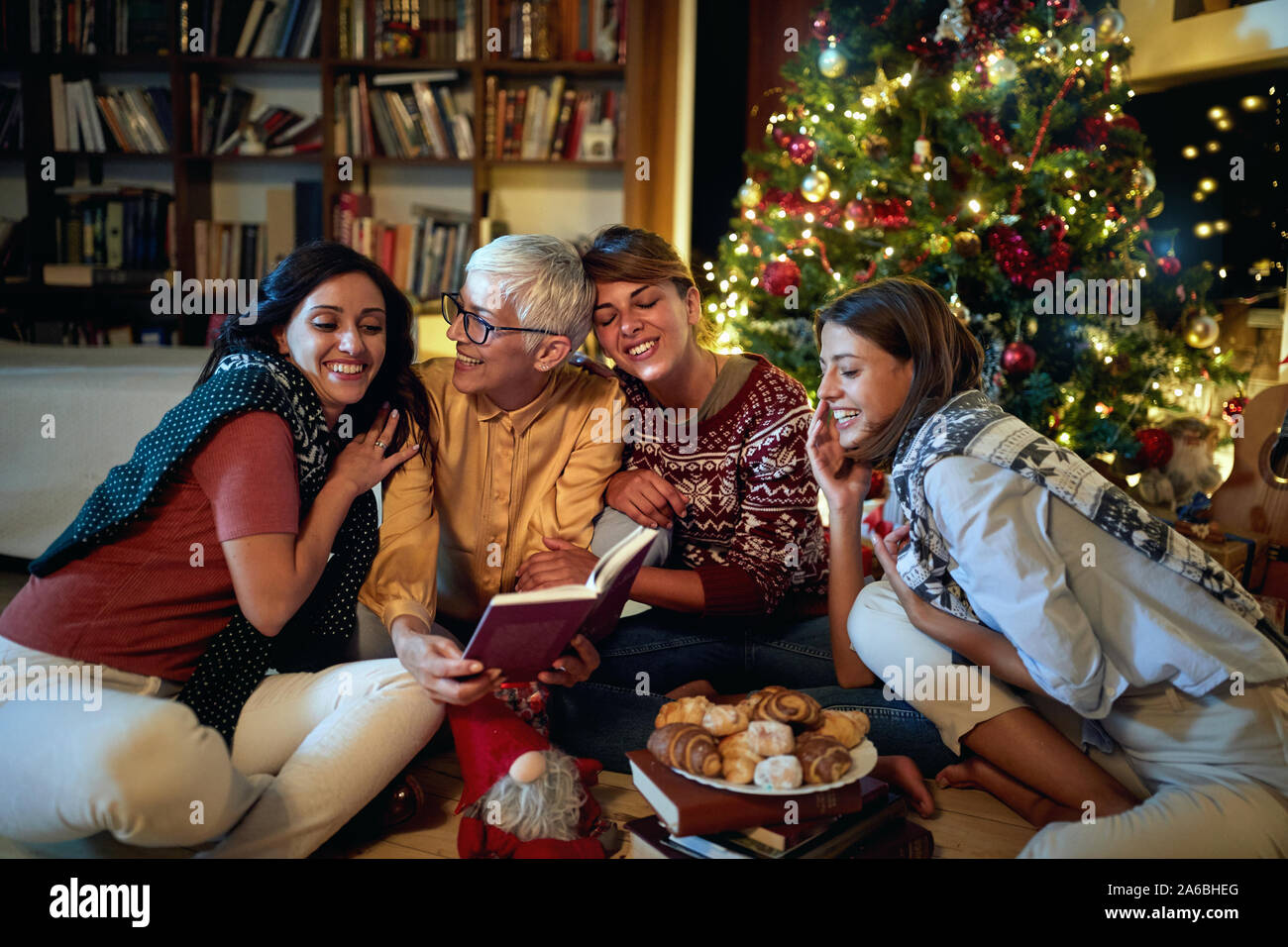 Cheerful mather  and her happy daughter together for Christmas in front of a decorated x-mas tree Stock Photo