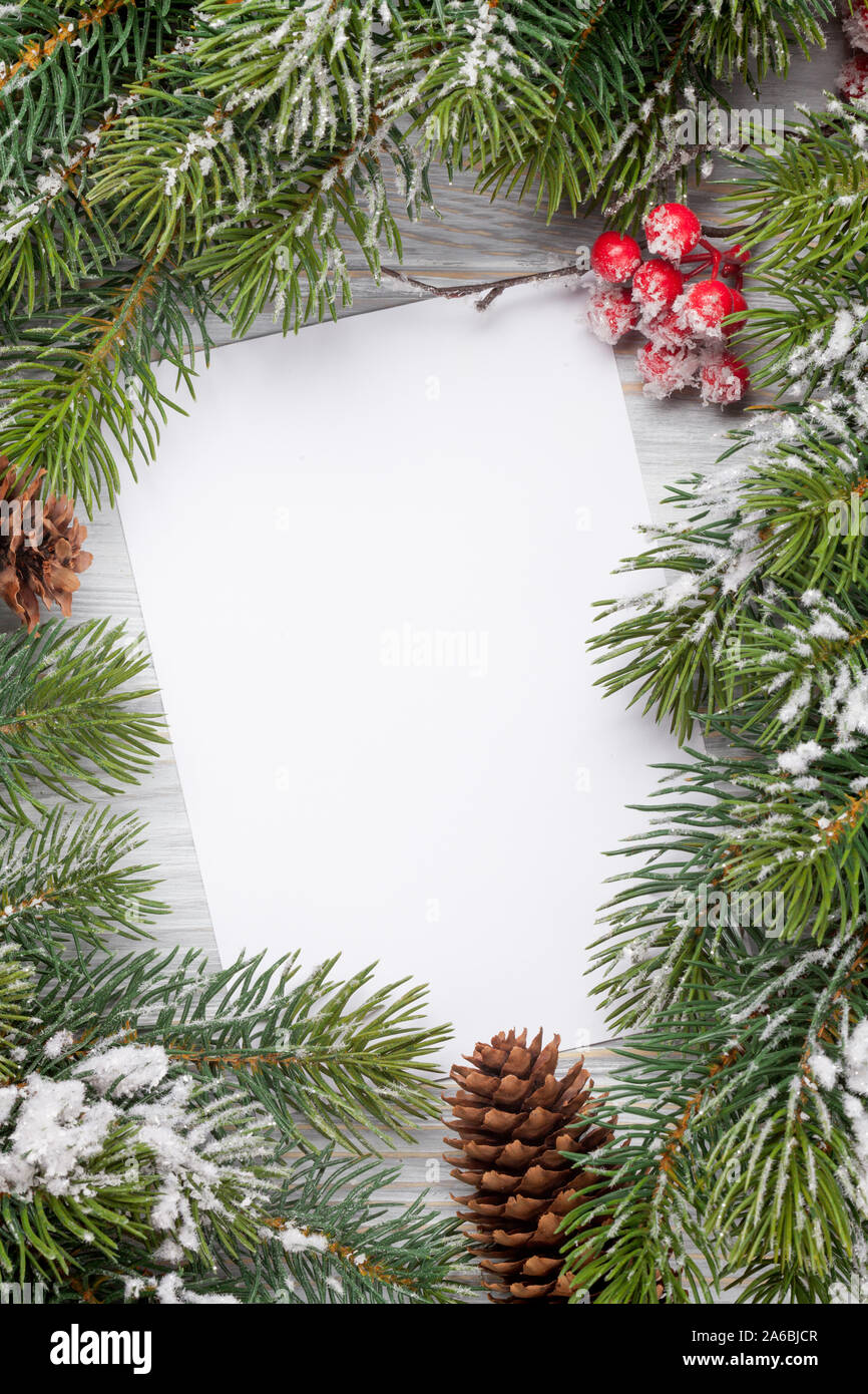 Christmas greeting card and fir tree branch over wooden texture ...