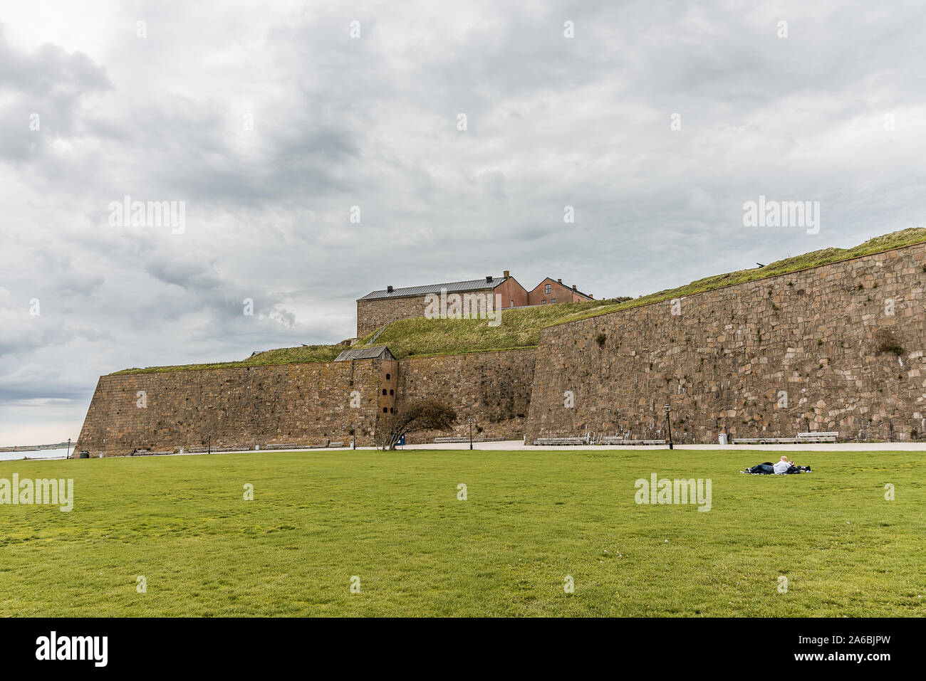 The fortress of Varberg is an old fortification, built in 1287-1300. a boy and a girl are resting on the grass in front of the walls, Varberg, Seweden Stock Photo