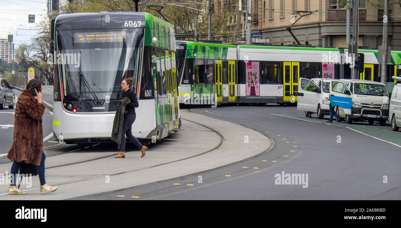 Commuters walking in front of public transport Yarra Trams tram in Spring Street Melbourne Victoria Australia. Stock Photo