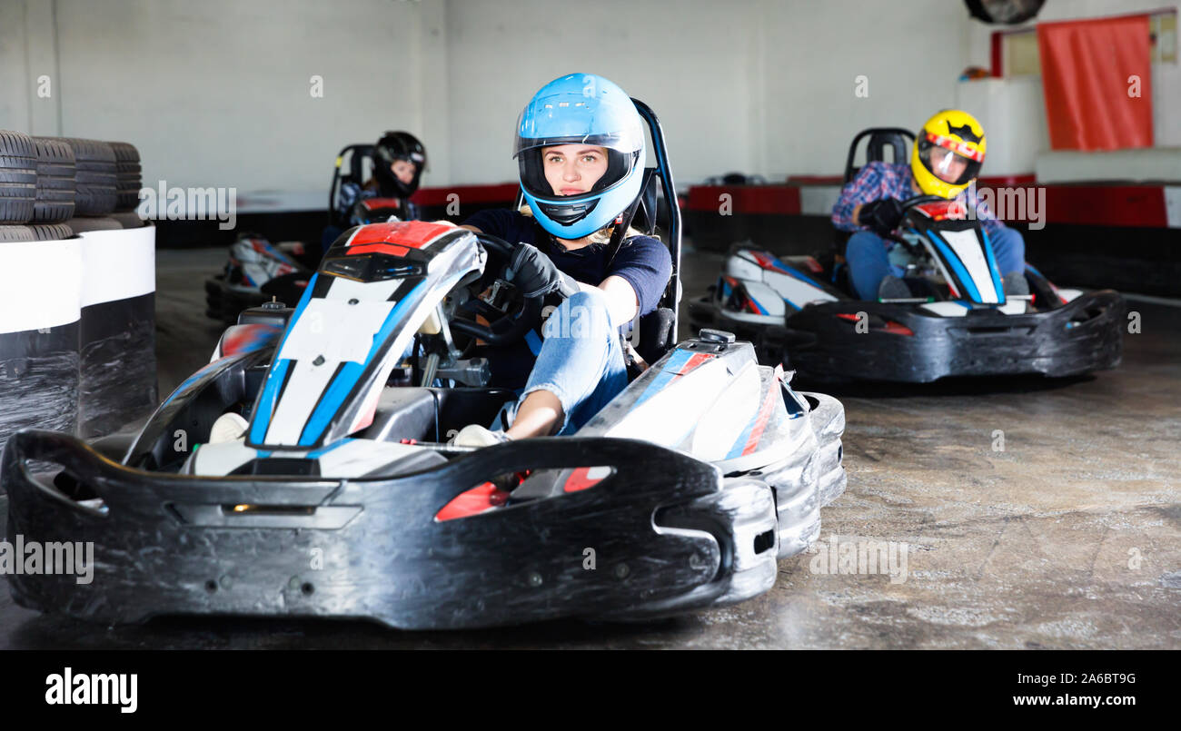 Group of glad cheerful positive smiling people driving go-carts at ...