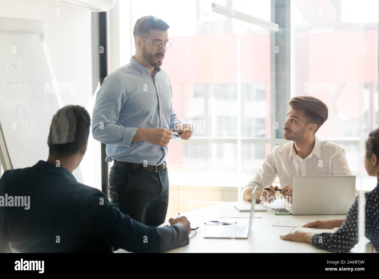 Business coach giving presentation to young team Stock Photo