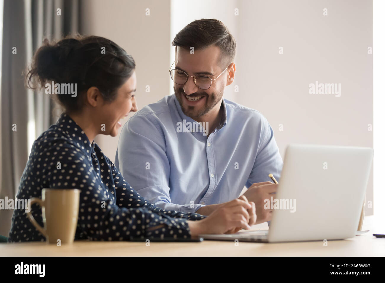 Laughing successful multiracial business couple in office Stock Photo