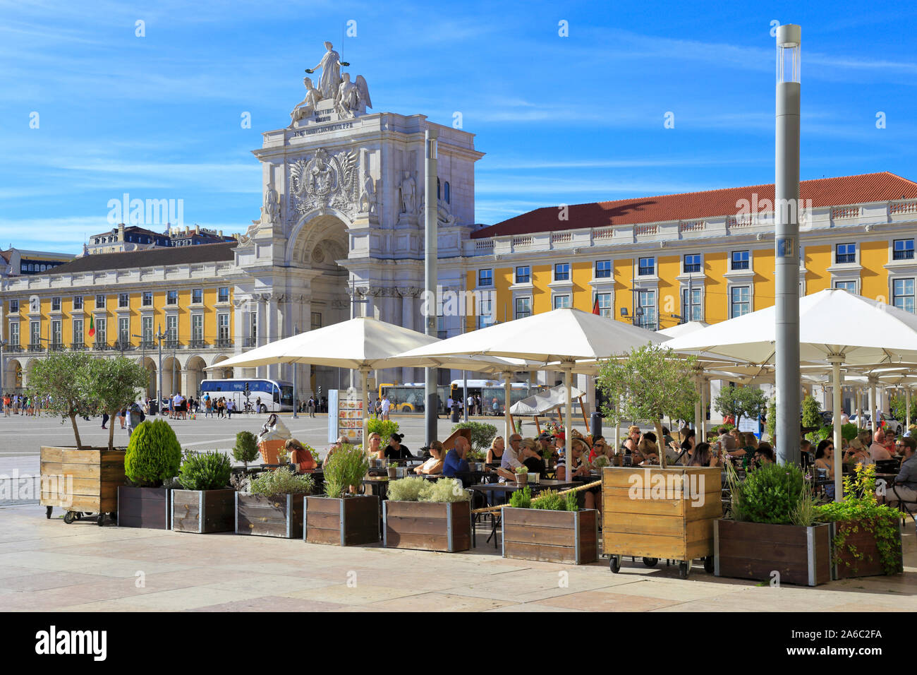 Diners at a restaurant in Parca do Comercio with Arco da Rua Augusta ornate triumphal arch in the background, Lisbon, Portugal. Stock Photo