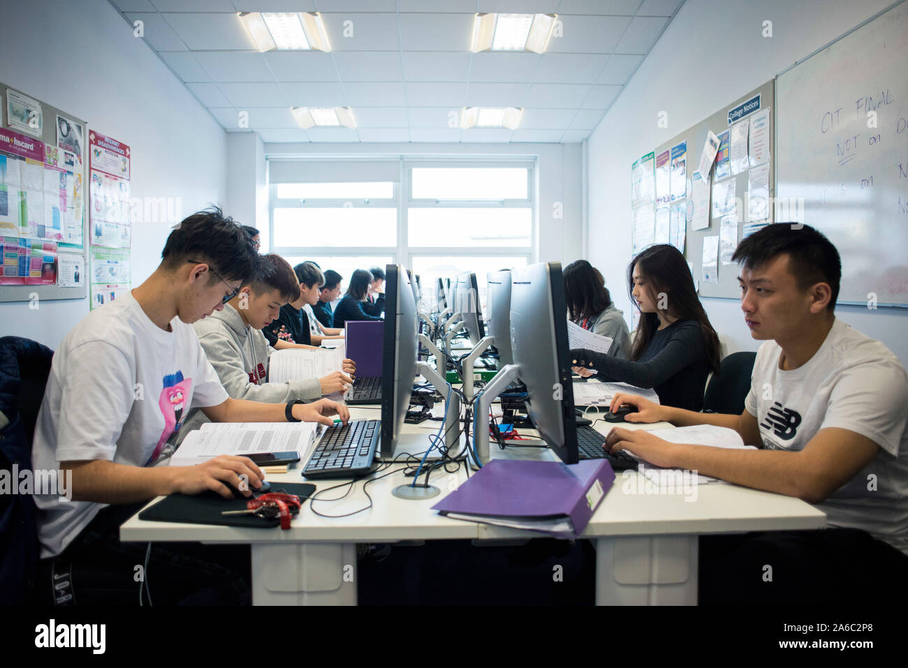 A computer technology class with students working and helping each