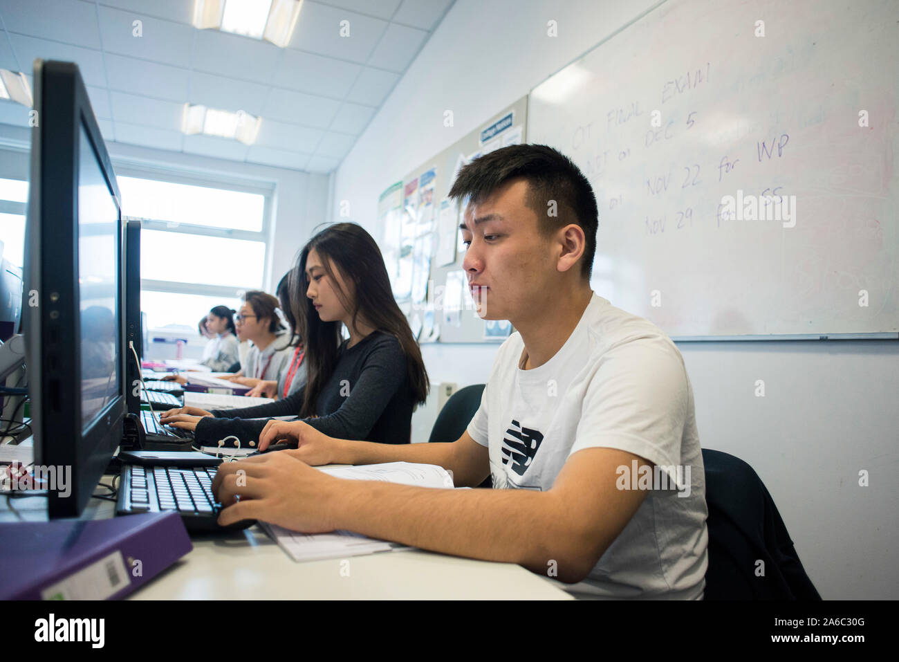 A computer technology class with students working and helping each
