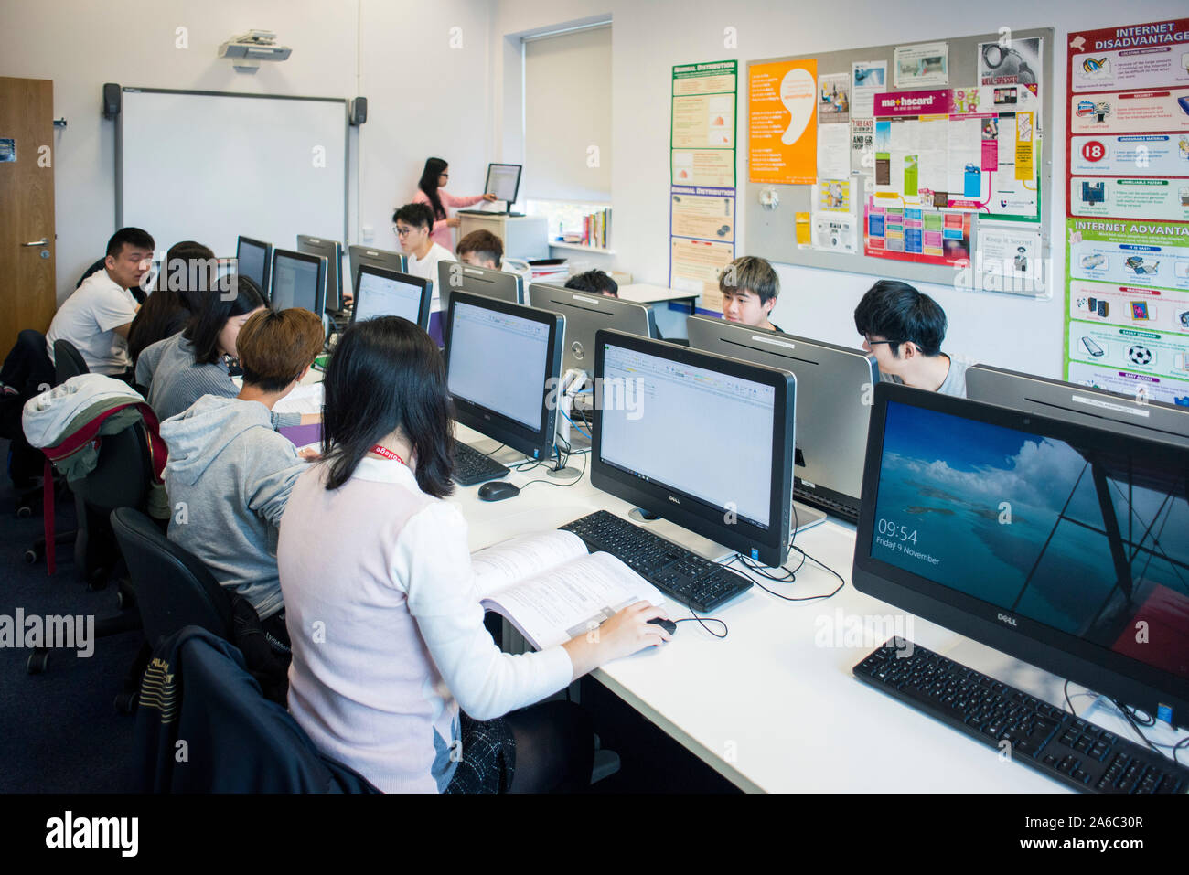 A computer technology class with students working and helping each