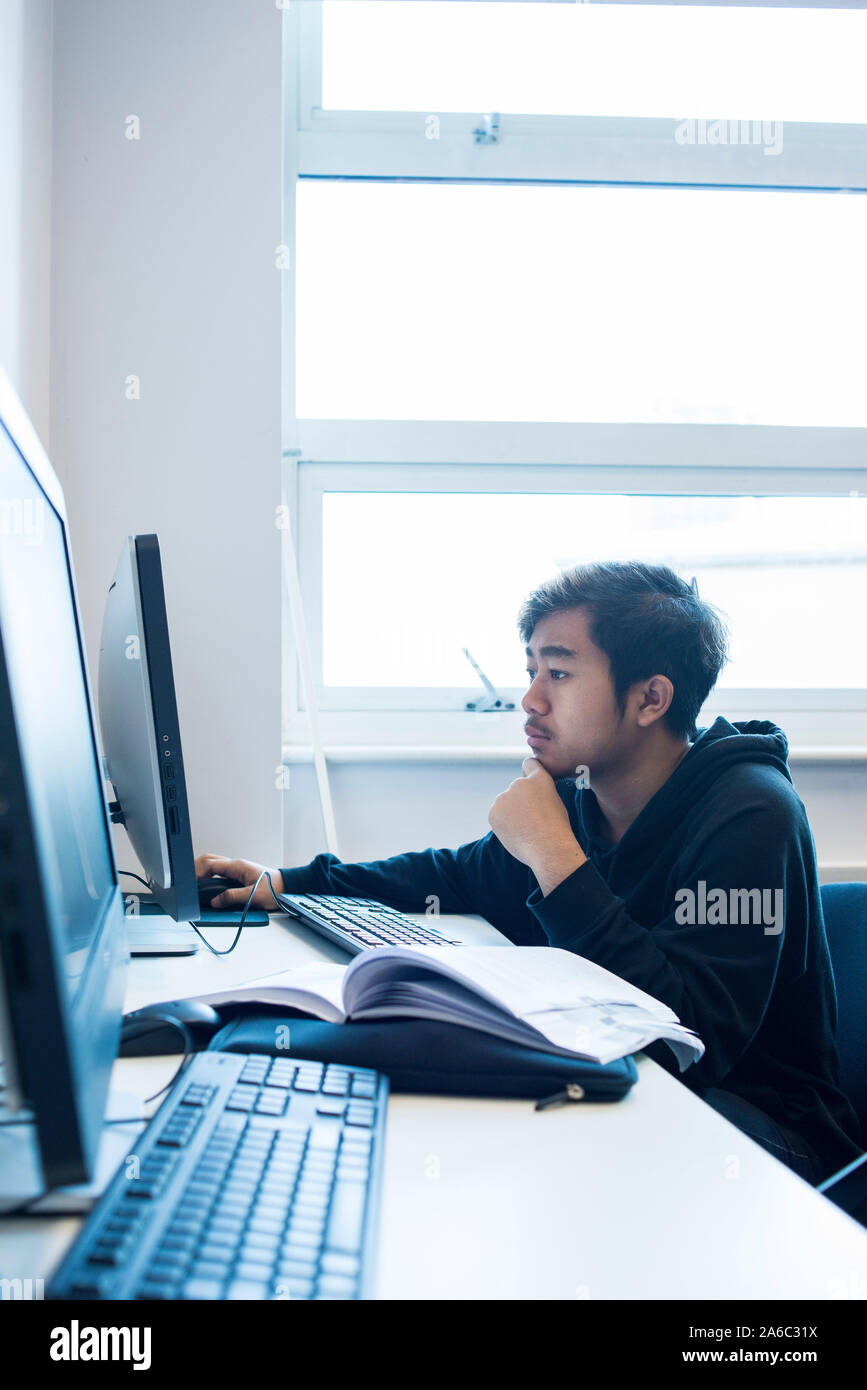 A computer technology class with students working and helping each