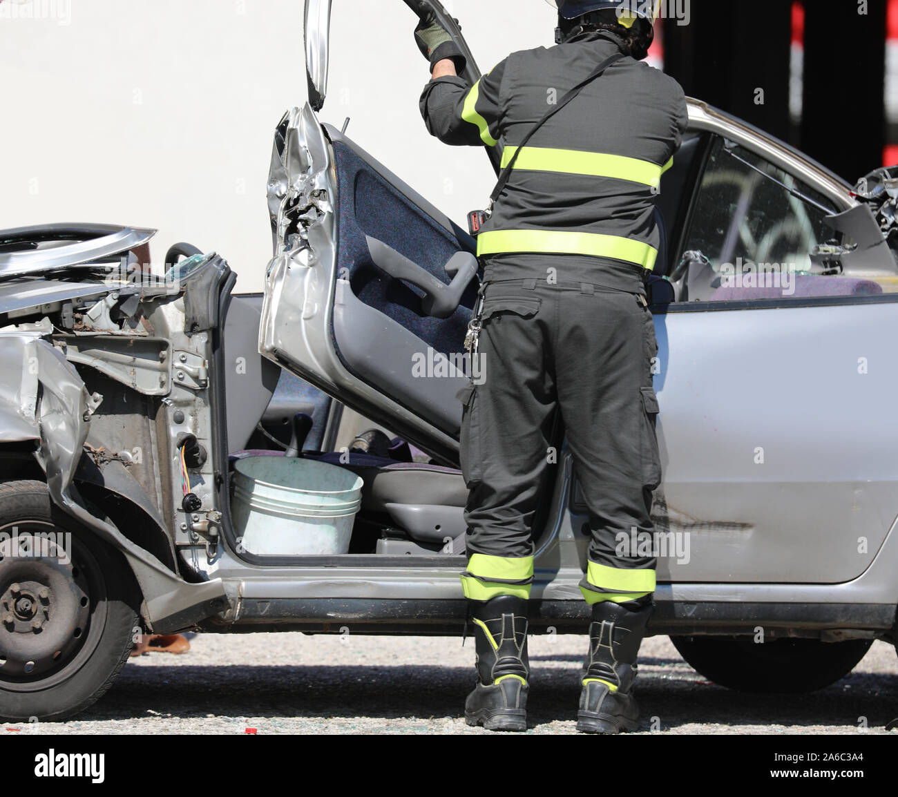 firefightera opens the damaged car after the road accident and the