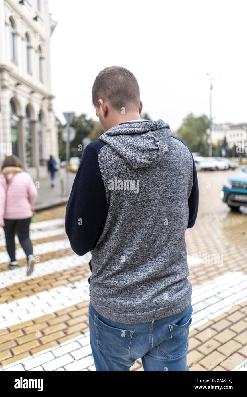 Young man using his mobile in the street Stock Photo