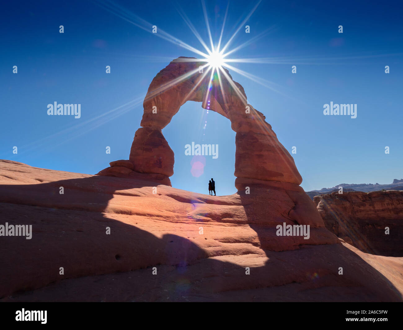 The Delicate Arch in Arches National Park, Moab, Utah, USA. Natural sandstone arch with sun above it. Stock Photo