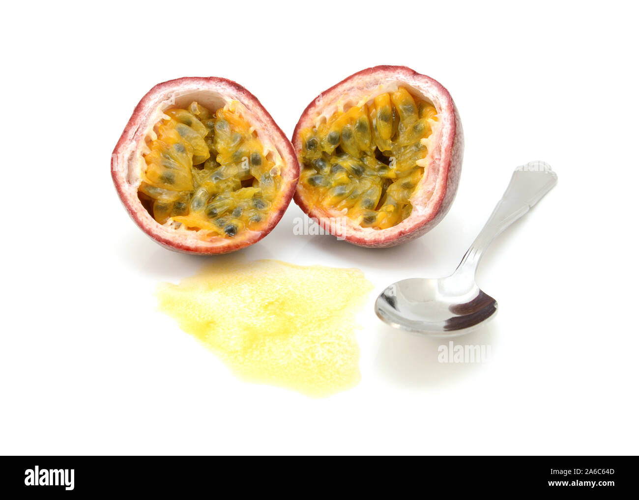 Passion fruit cut in half with juicy pulp and seeds, ready to eat with a spoon, on a white background Stock Photo