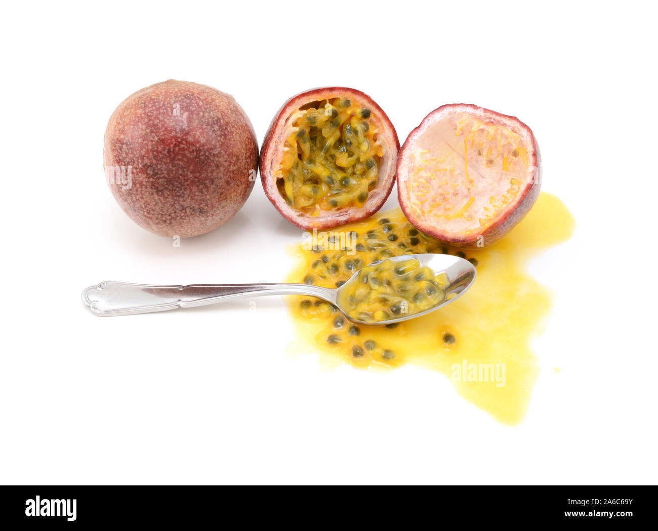 Whole and halved passion fruits ready to eat with a spoon, with spilled