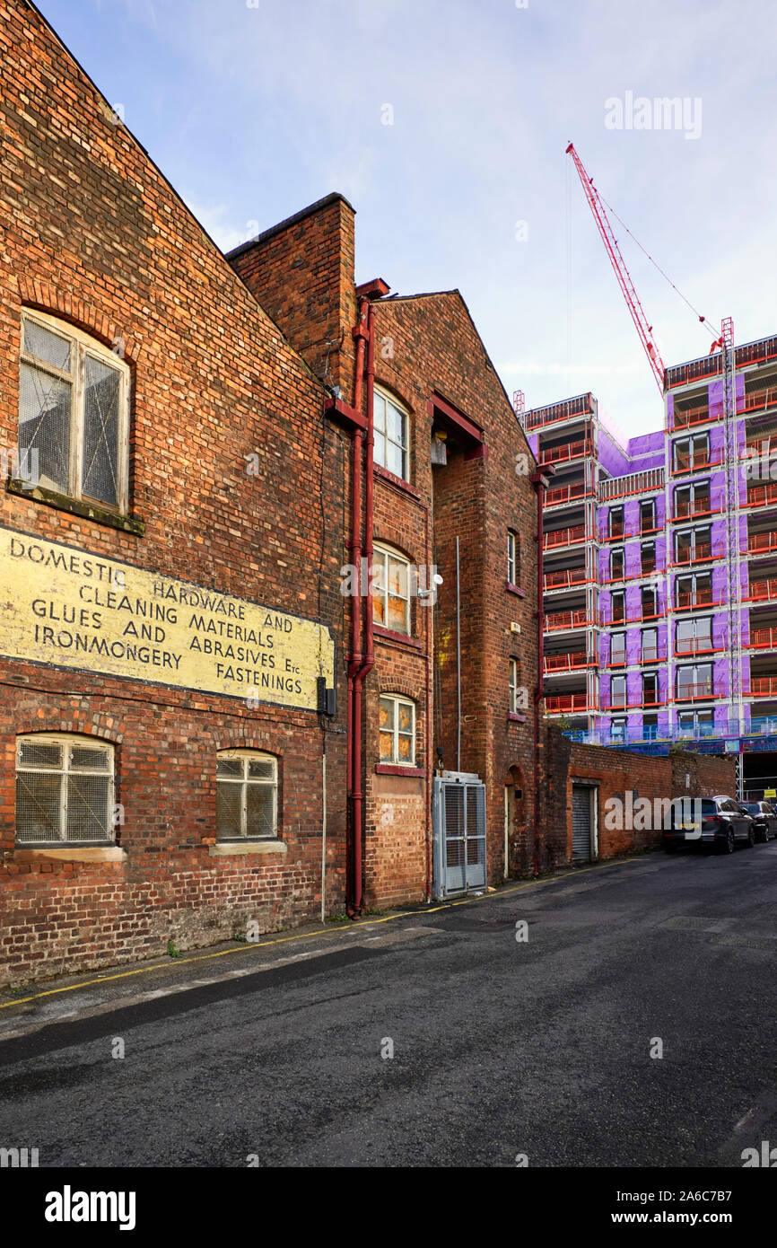 Older warehouse building in the Baltic Triangle part of Liverpool with newer buildings alongside being constructed Stock Photo