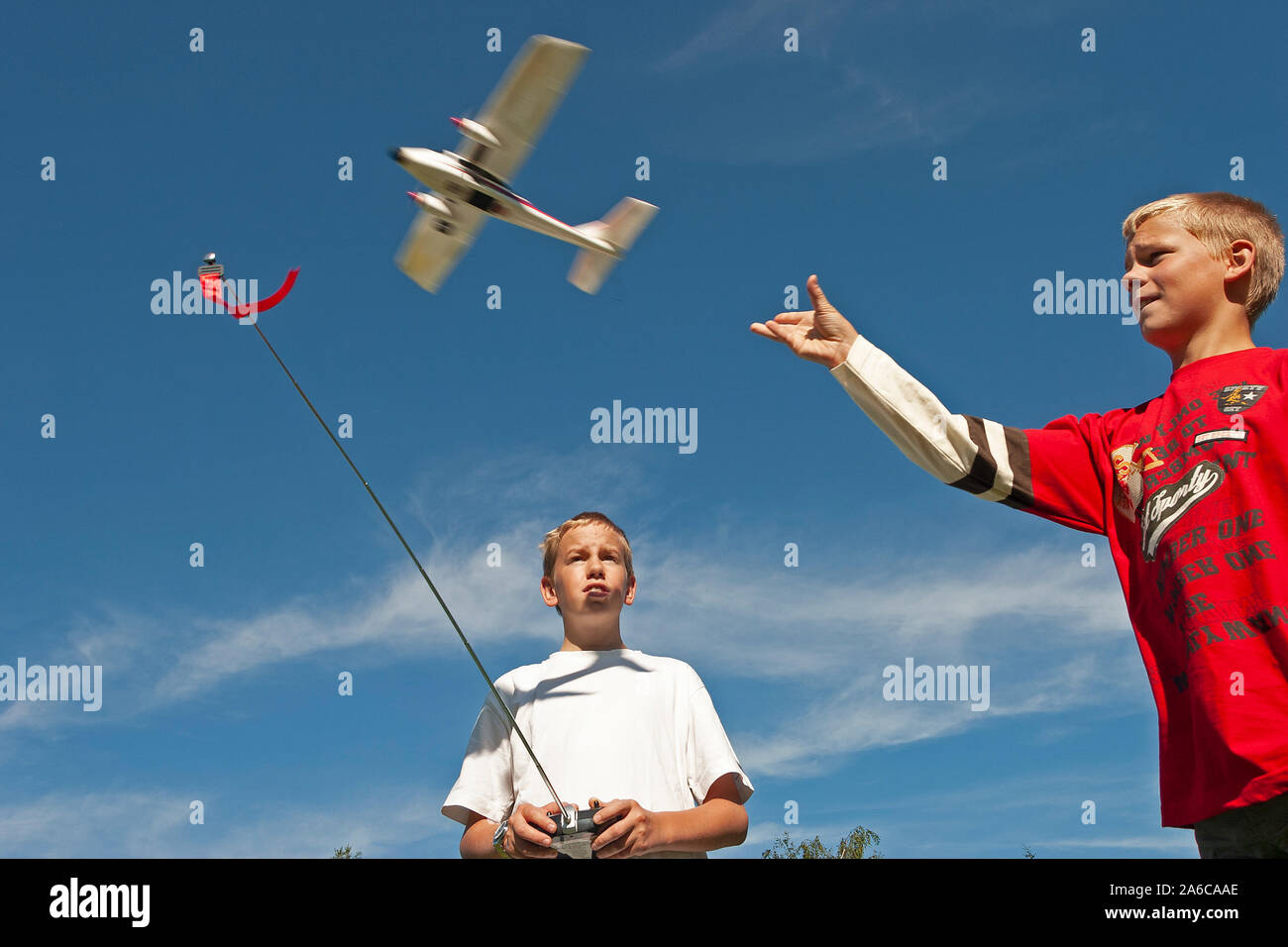Two boys are flying a model plane. Stock Photo
