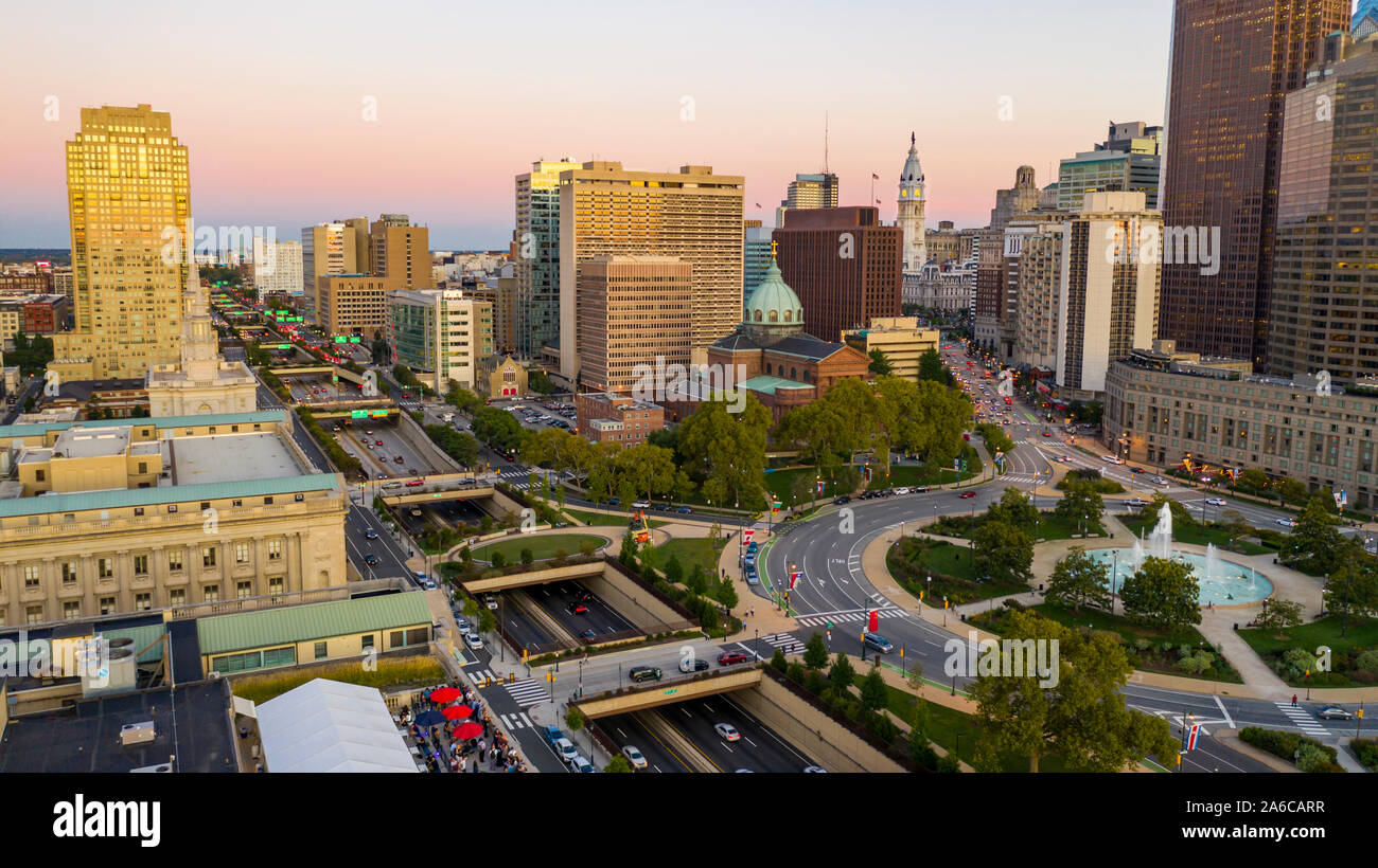 Vehicle traffic circles around the fountain at Logan Square in the bustling urban core of Philadelphia PA Stock Photo