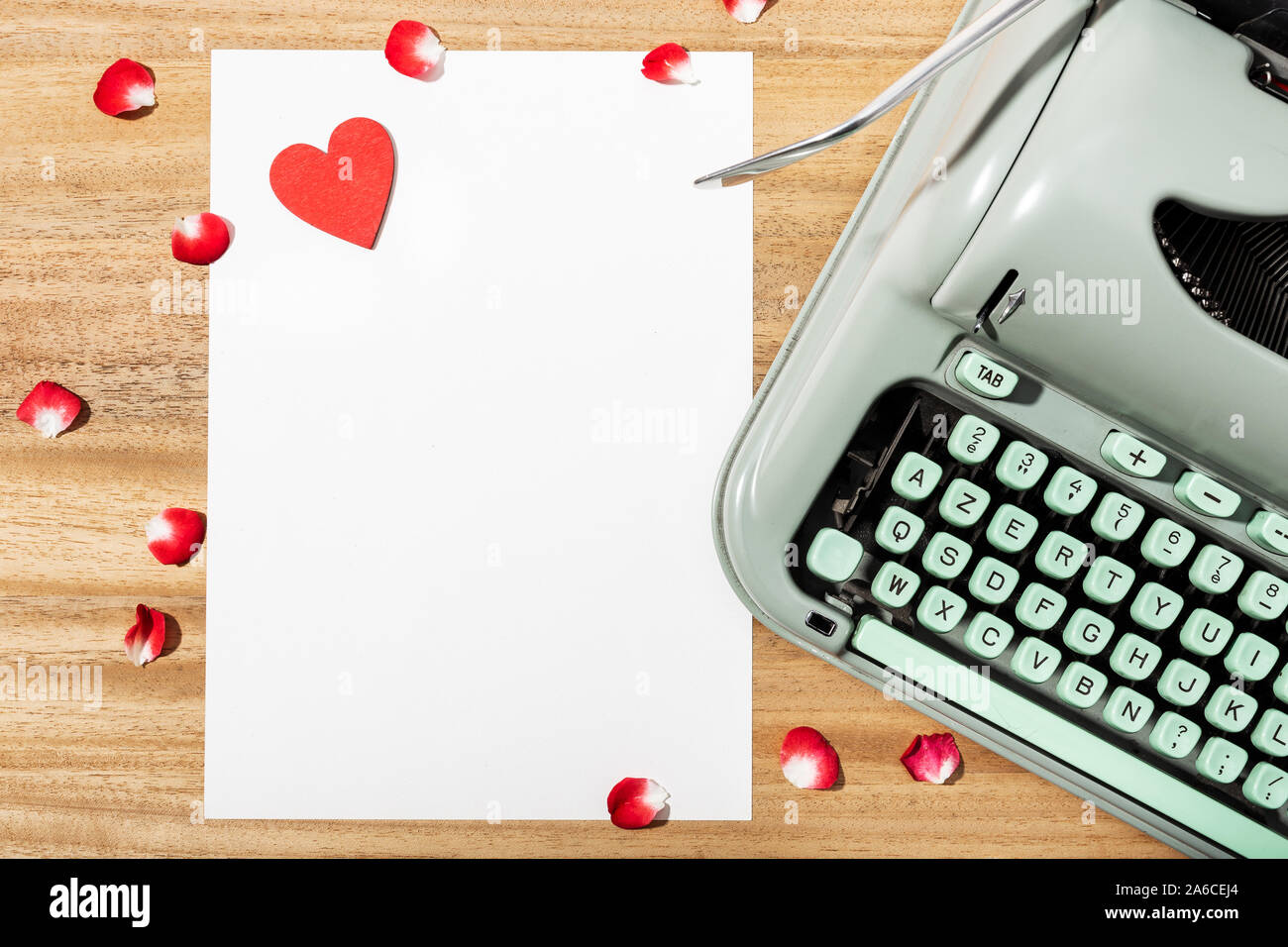 Love letter. Desk with blank paper, retro typewriter and red heart