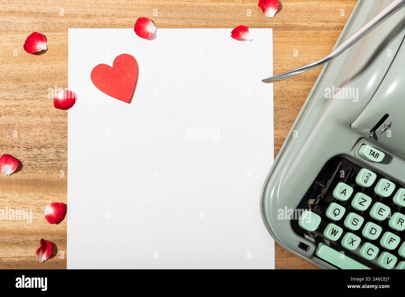Love letter. Desk with blank paper, retro typewriter and red heart