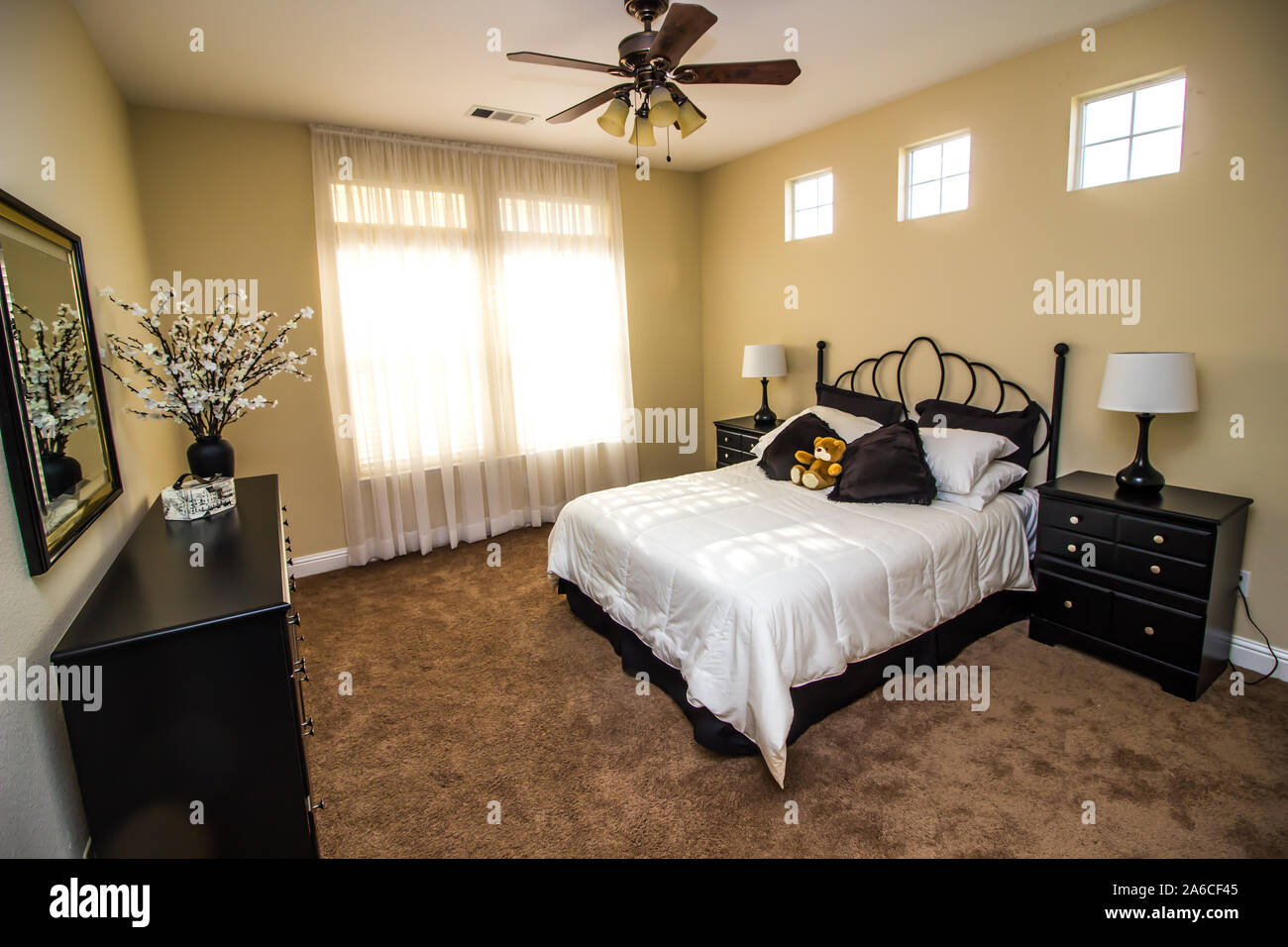 Guest Bedroom With Bed, Headboard, Nightstands And Black Dresser Stock