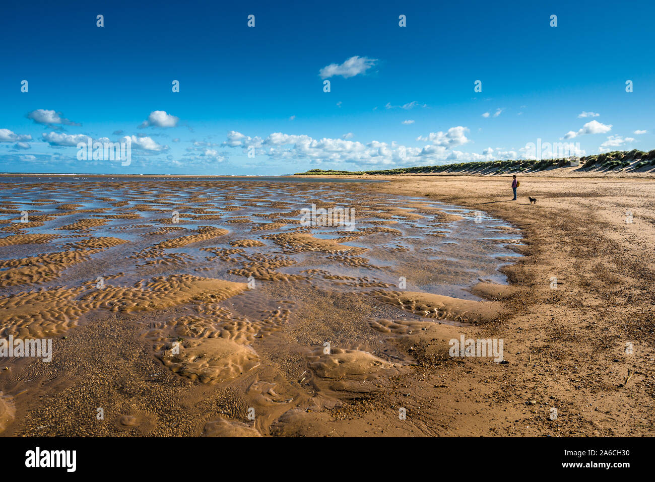 Patterns made by tide pools of water at low tide on Burnham Overy Staithe beach on Holkham bay, North Norfolk coast, East Anglia, England, UK. Stock Photo
