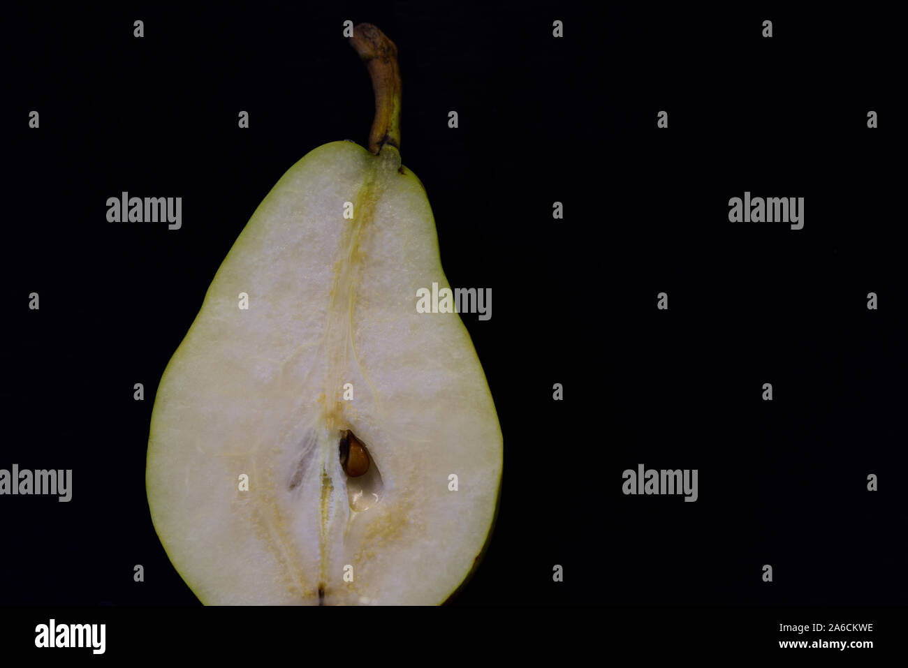 A half fresh pear lies on dark background Stock Photo