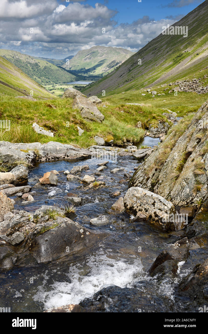 Kirkstone Beck stream running down Kirkstone Pass to Brother's Water lake stopped by Place Fell mountain in Lake District England Stock Photo
