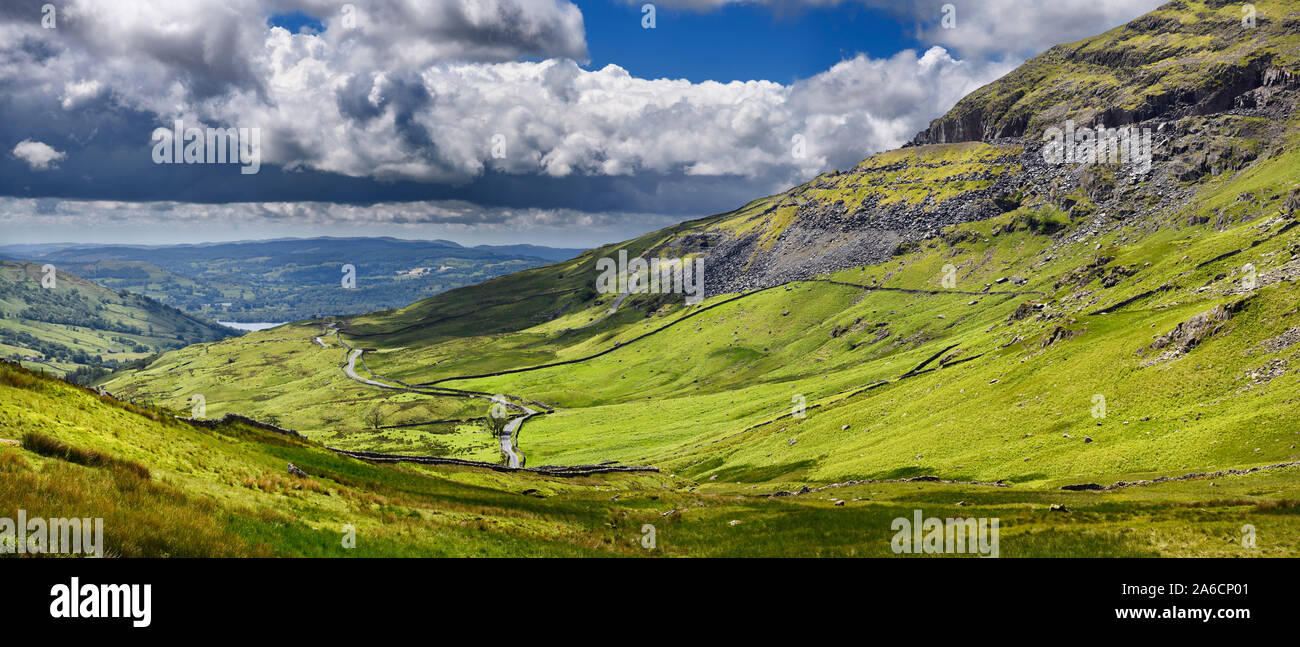 Panorama of the Struggle road at Kirkstone Pass leading to Windermere lake Ambleside with Red Screes mountain on right in Lake District England Stock Photo