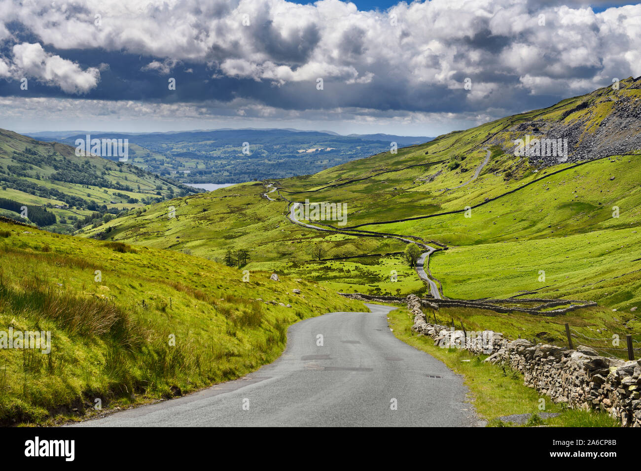 The Struggle road at Kirkstone Pass leading to Windermere lake Ambleside with Snarker Pike of Red Screes mountain on right in Lake District England Stock Photo