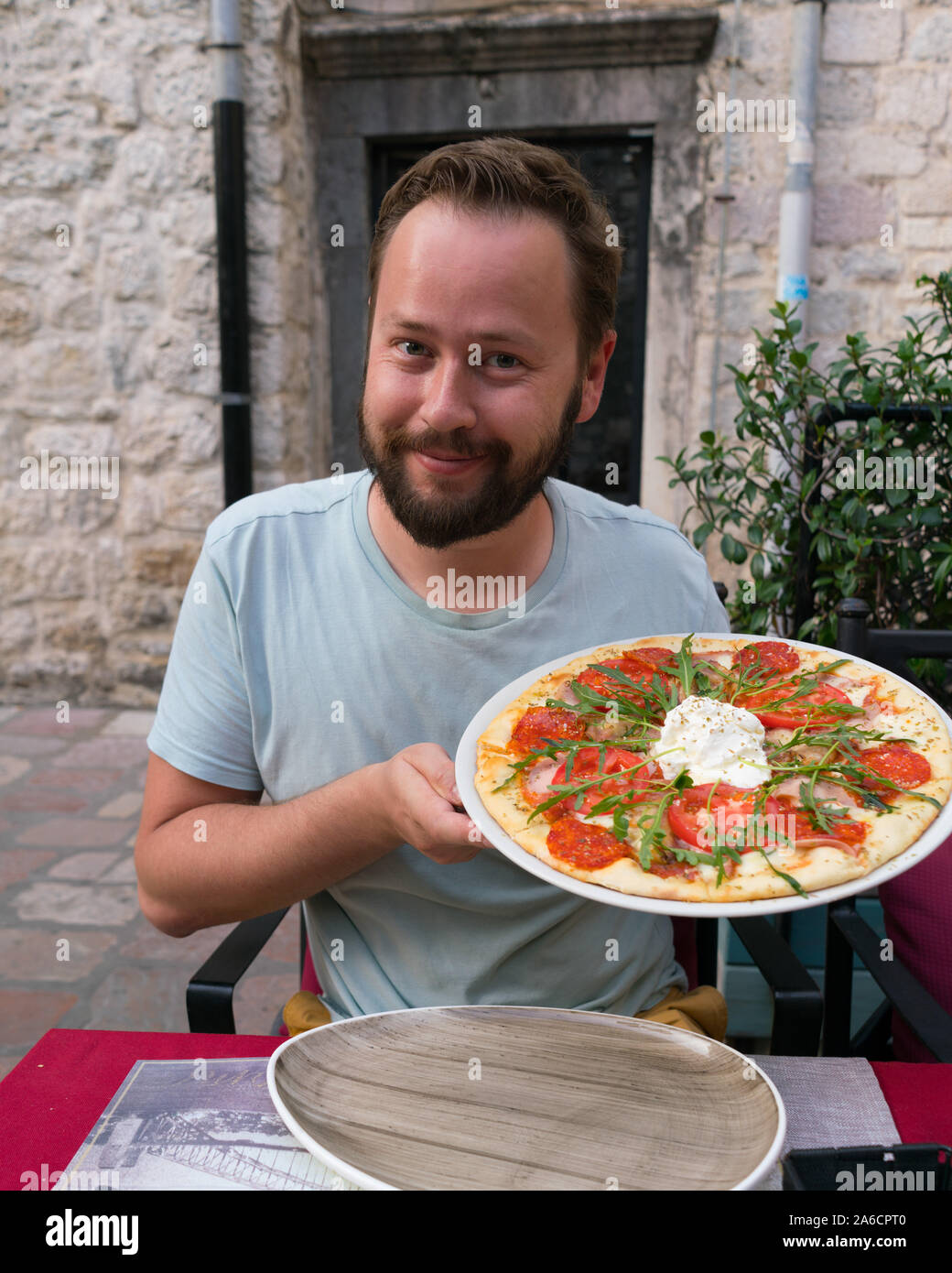 smiling bearded man posing with pizza in his hands Stock Photo