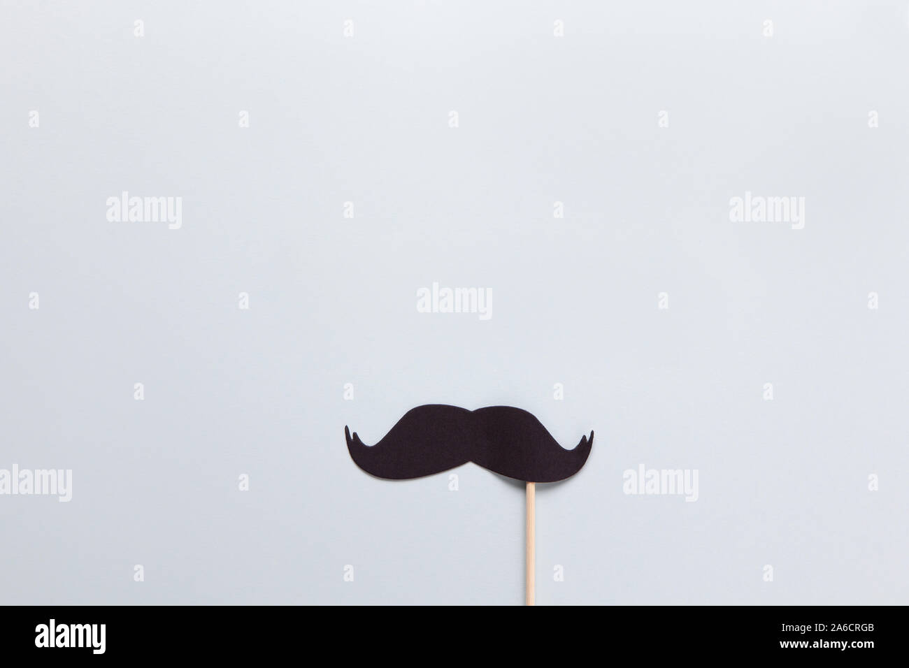Accessory in form of black moustache on stick on grey background with place for text. Concept men's health, prostate cancer awareness month, no shave, Stock Photo
