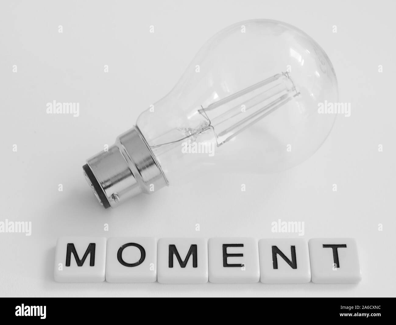 Black and white photo of modern bayonet LED lightbulb with word moment ...