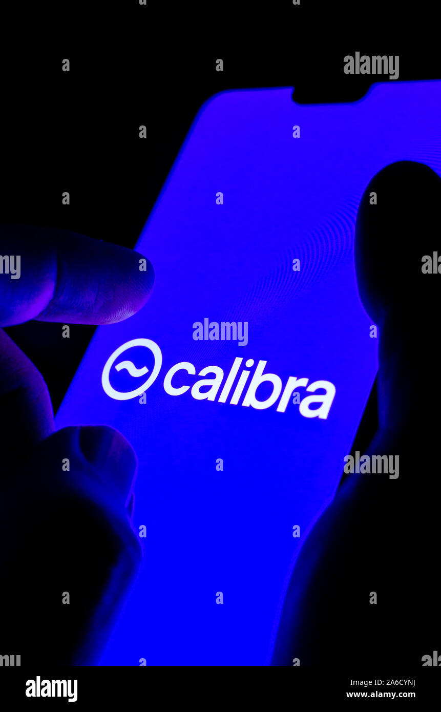 Calibra wallet logo on a smartphone screen and finger is about to touch it. Conceptual photo for Facebook Libra global currency.  Vertical photo. Stock Photo