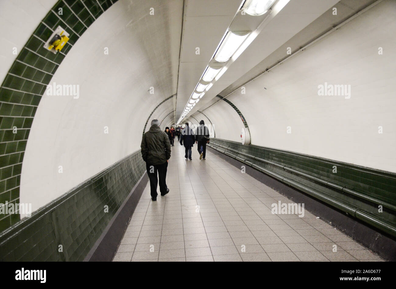 Londoners walk through a tunnel at an underground London tube station ...