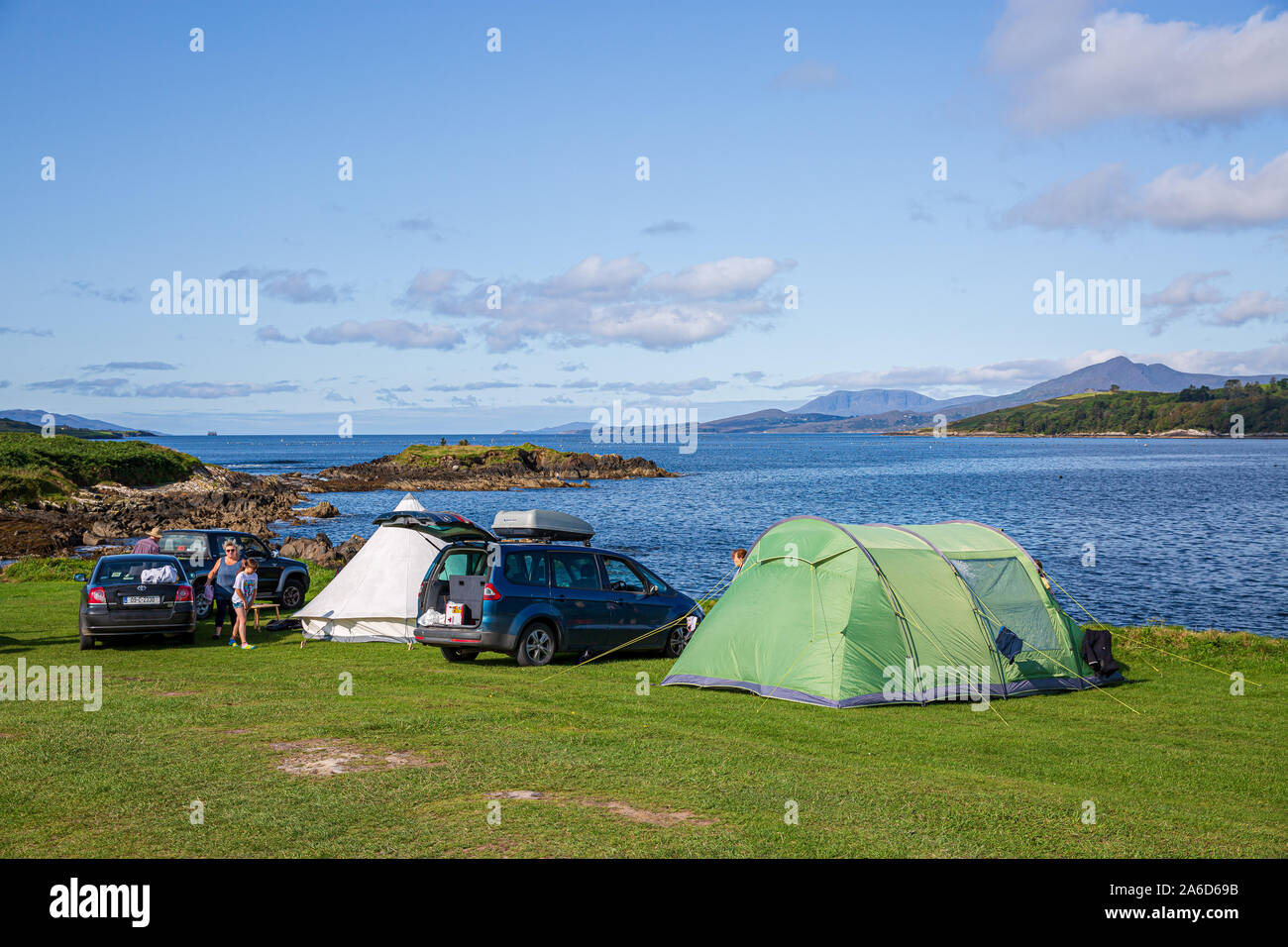 Family camping holidays at the Eagle Point Camping site near Bantry , West Cork, Ireland. Tents are being set up at the banks of Bantry Bay. Stock Photo