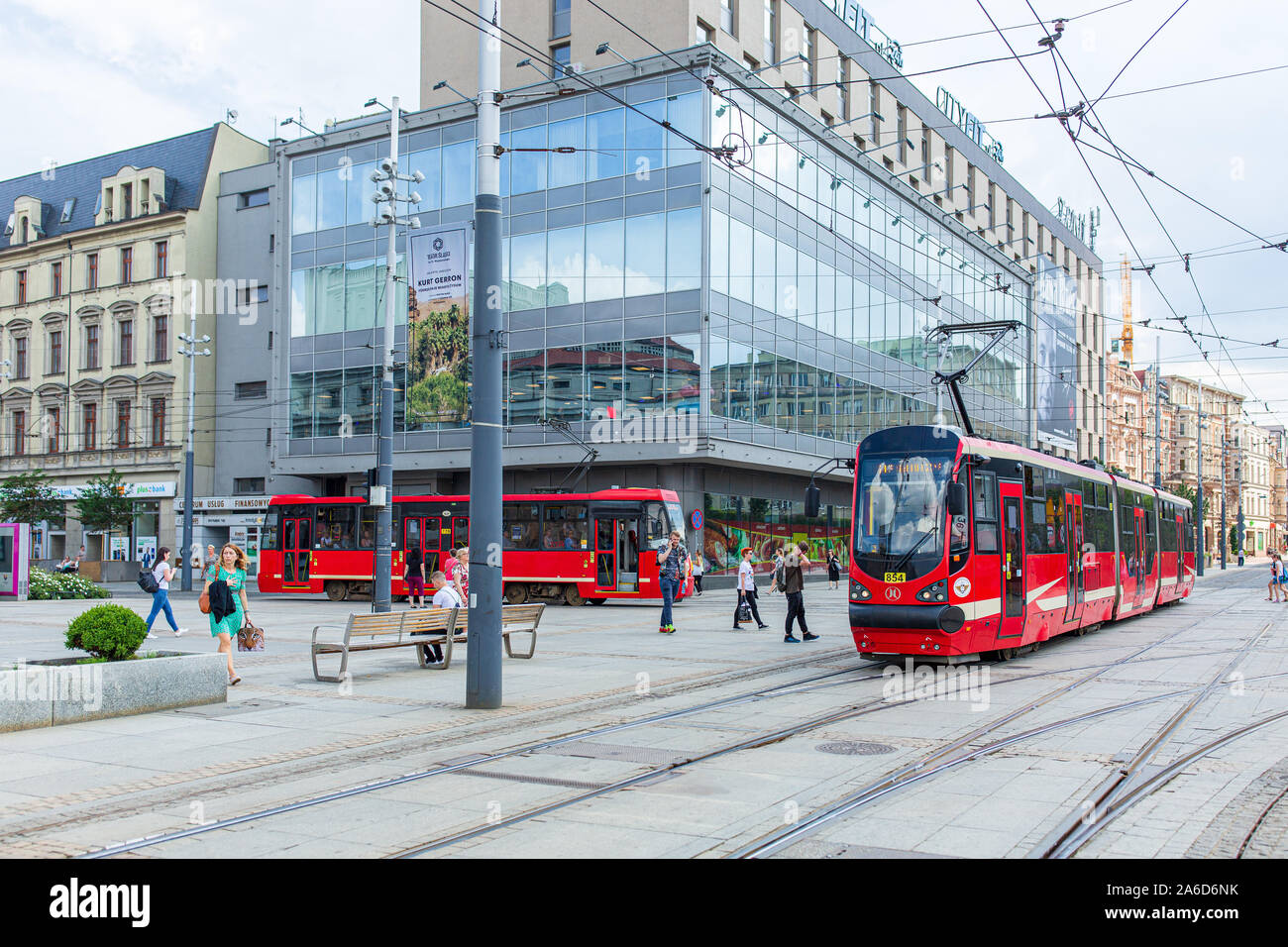 Red trams and pedestrians at the town square of Katowice in Poland. Public transport. Stock Photo