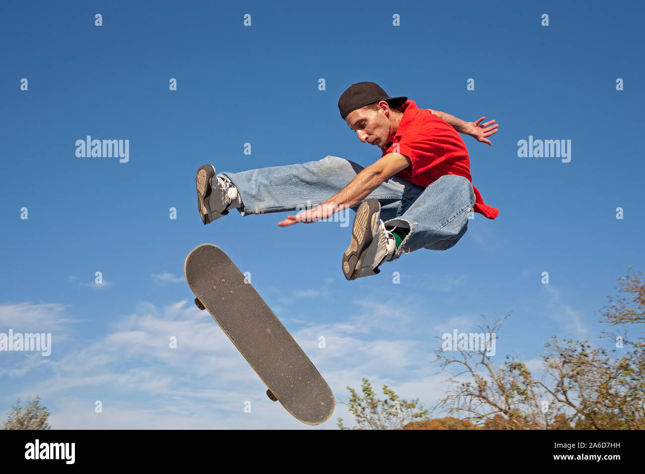 A young man is jumping with his skateboard. Stock Photo