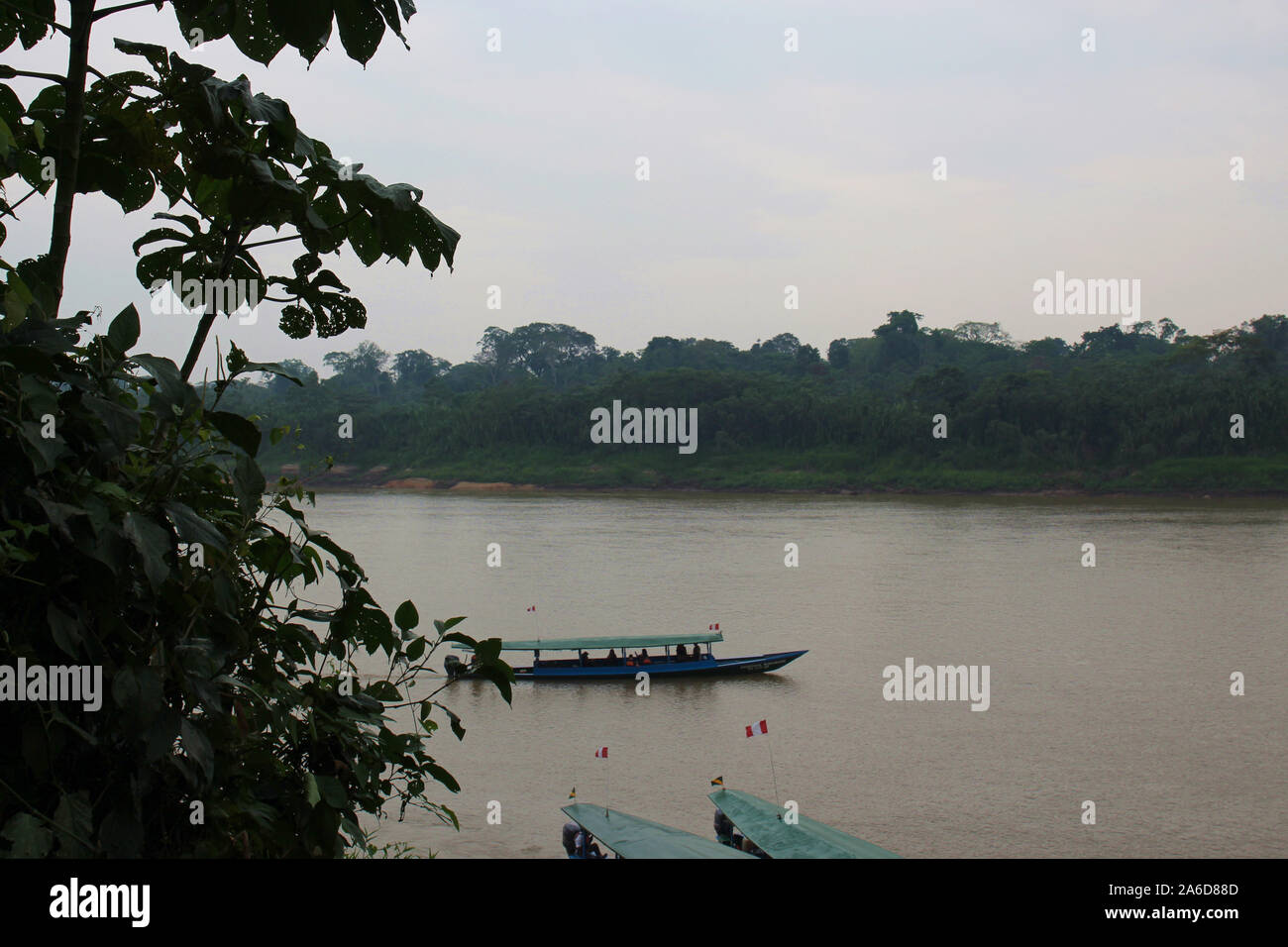 Three large, covered canoes on the Tambopata River, surrounded by rainforest in Madre De Dios, Peru Stock Photo