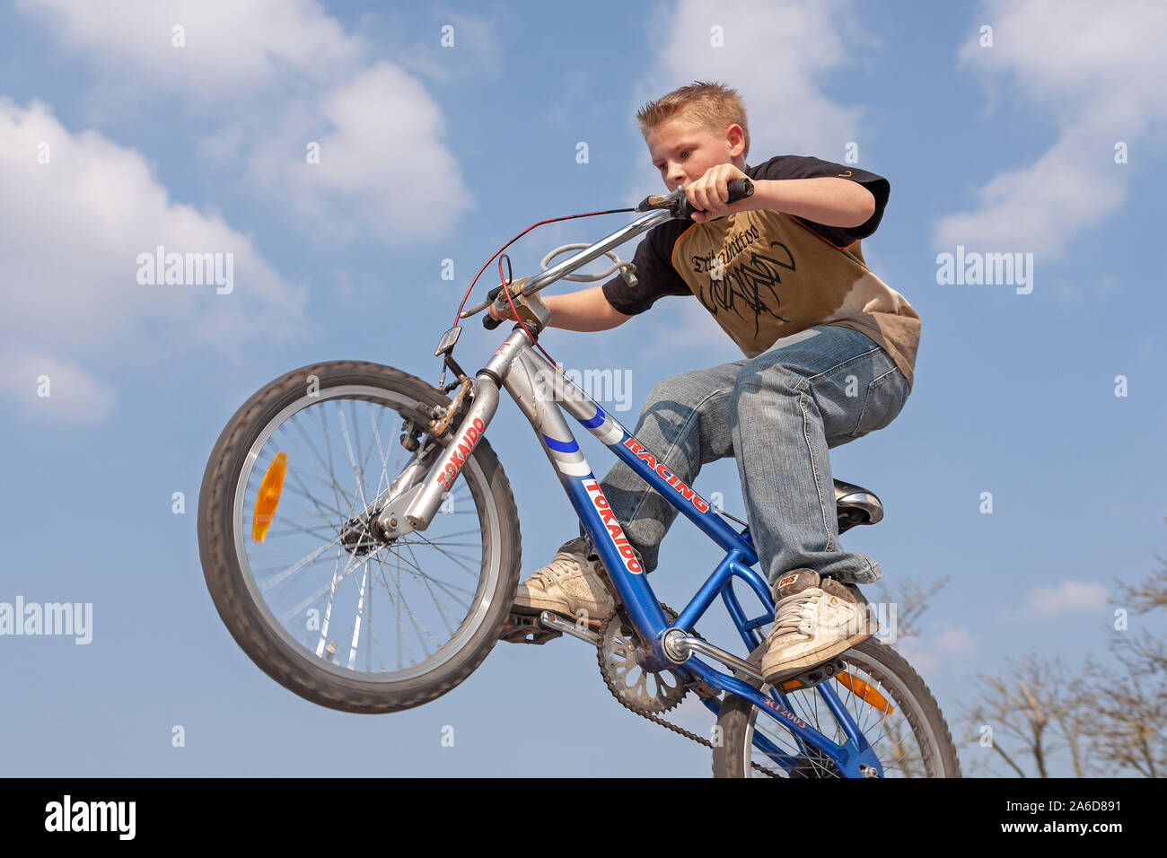A jung boy is jumping with his bike Stoc image