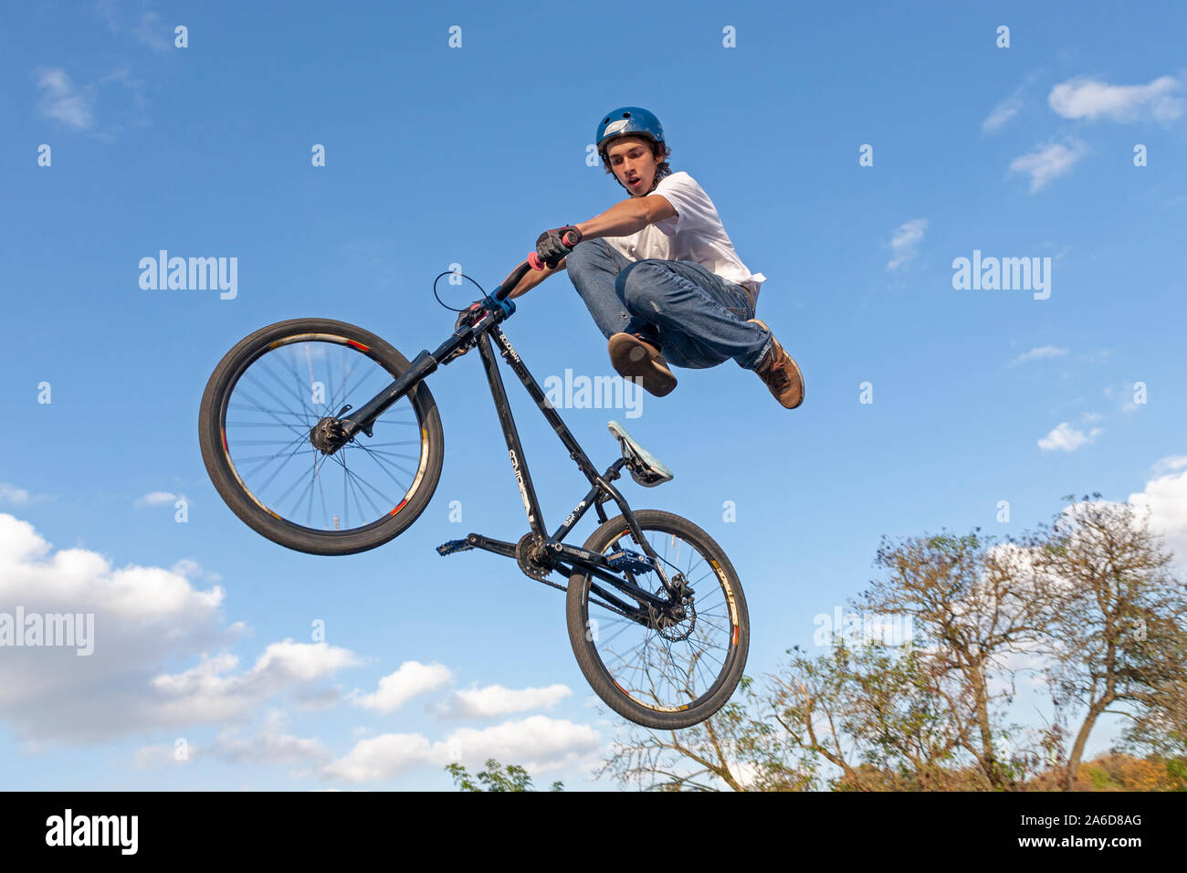 A teenage boy is jumping with his bike. Stock Photo