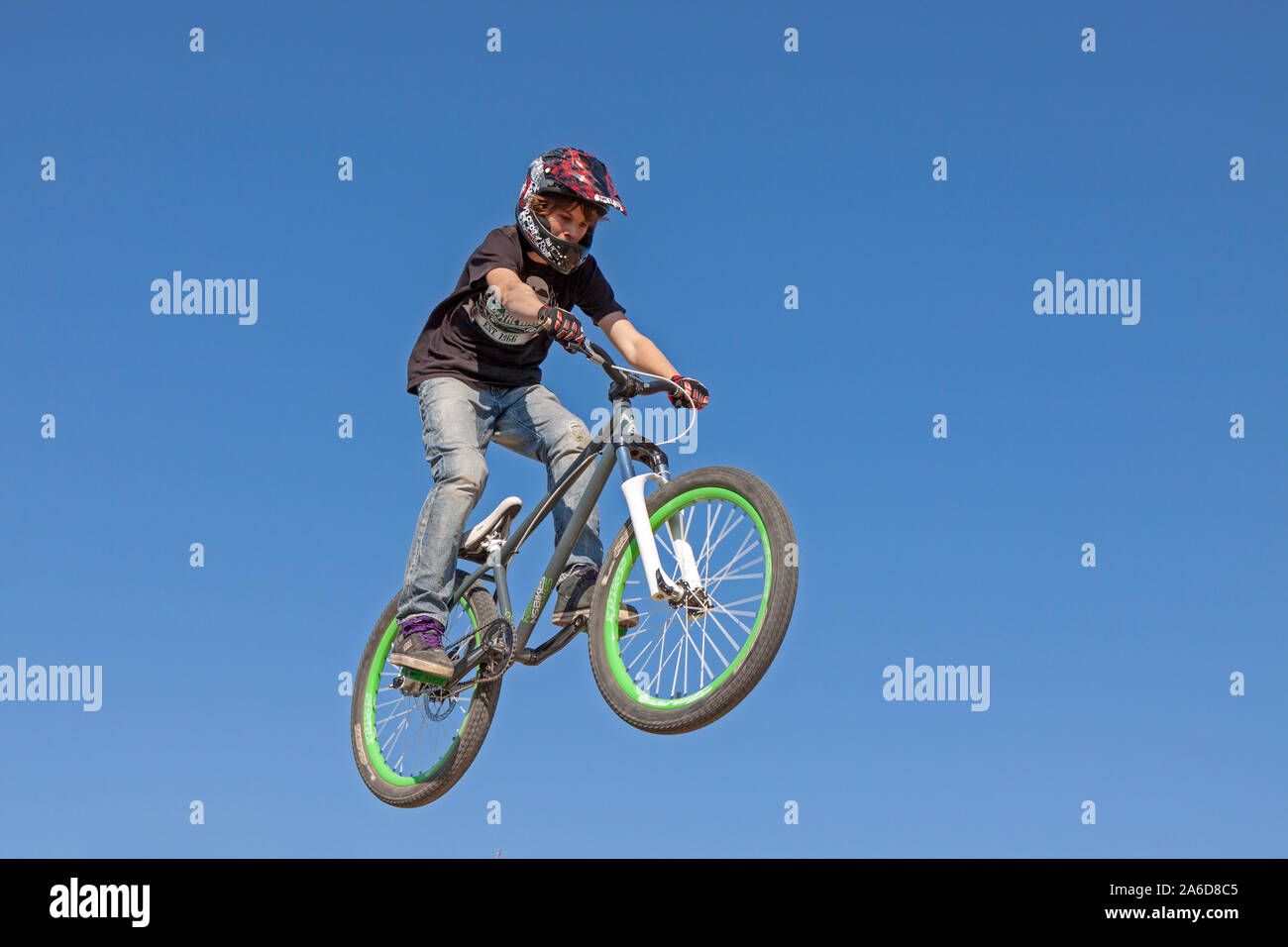 A teenage boy is jumping with his bike. Stock Photo